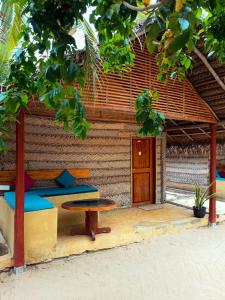 un lit et une table devant un bâtiment dans l'établissement Coco Cottage Kite Surfing-Kalpitiya, à Kandakuli 15 autres photos