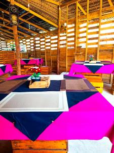 une chambre avec des tables et des chaises roses et bleues dans l'établissement Coco Cottage Kite Surfing-Kalpitiya, à Kandakuli