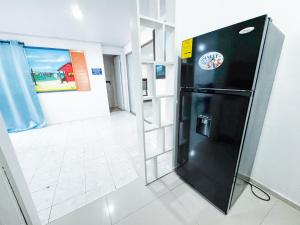 a black refrigerator with a sticker on it in a room at Apartamentos Turísticos In Di Town in San Andrés +22 photos