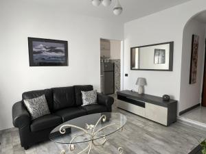 a living room with a black couch and a glass table at A casa di Alida in Cotulo