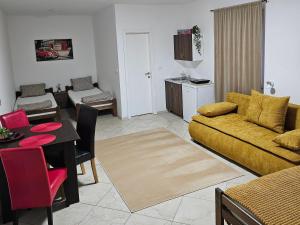 a living room with a yellow couch and a table at SOBE AVA in Palić