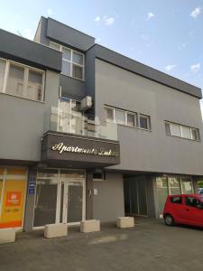 een gebouw met een rode auto ervoor geparkeerd bij Apartments Lukas 5 in Zadar +2 foto's