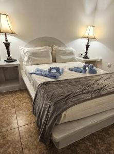 a bed with two blue towels on top of it at Santorini Studios Pleasure in Perissa