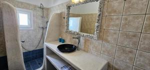 a bathroom with a sink and a mirror at Santorini Studios Pleasure in Perissa +115 photos