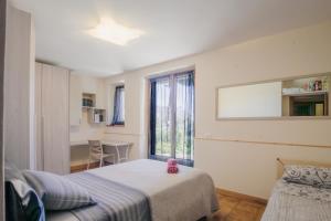 a bedroom with two beds and a table and a window at Le Margherite in Castiglione del Lago