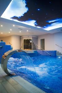 - une piscine avec toboggan dans un bâtiment dans l'établissement W Krainie Alicji, à Nałęczów