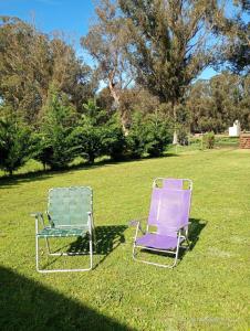 two chairs sitting on the grass in a field at Cabaña El Atardecer in Necochea