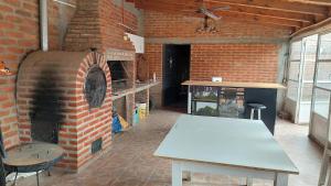 a brick room with a table and a brick oven at El Cerrito del Valle in Santa María