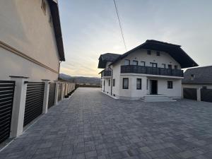 a white house with a black roof and a driveway at Casa Pop in Petrova