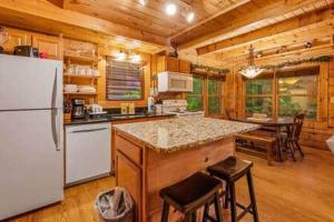 a kitchen with a white refrigerator and a table at In the Pines. Great location. Privacy in Hornet