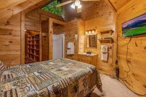 a bedroom with a bed in a wooden cabin at In the Pines. Great location. Privacy in Hornet