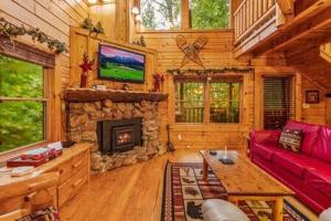 a living room with a red couch and a fireplace at In the Pines. Great location. Privacy in Hornet +16 photos