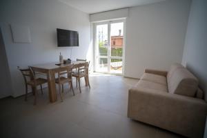 un soggiorno con un divano e un tavolo con sedie di 16 Nevoso Palace a Milano