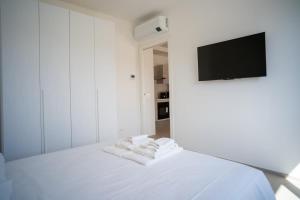 una camera da letto con un letto bianco con asciugamani sopra di 16 Nevoso Palace a Milano