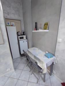 une petite cuisine avec une table et un réfrigérateur dans l'établissement Chambres d'hôtes - Les Orchidées, à Perpignan