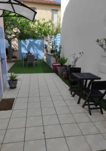 eine Terrasse mit 2 Bänken und einem Tisch in der Unterkunft Chambres d'hôtes - Les Orchidées in Perpignan + 8 Fotos