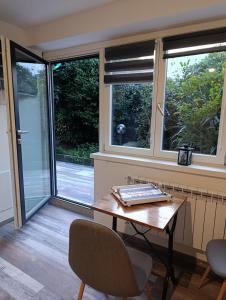 Habitación con mesa, 2 sillas y ventanas. en Altea, en Dervio