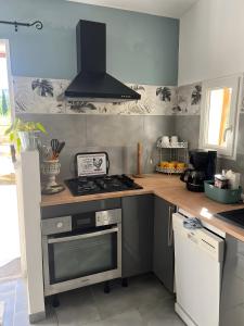 eine Küche mit Herd und Herd oberen Backofen in der Unterkunft Maisonnette au coeur du Luberon in Gondonnets