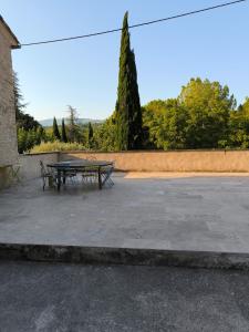 einen Picknicktisch und zwei Bänke im Innenhof in der Unterkunft Maisonnette au coeur du Luberon in Gondonnets