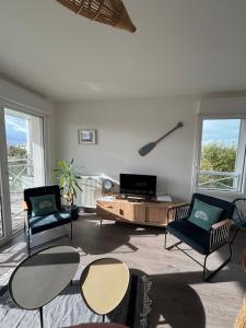 a living room with three chairs and a coffee table at Les Cavaliers in Cabourg
