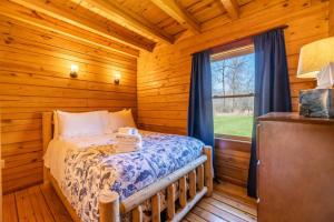 Un dormitorio con una cama en una cabaña de troncos en Rustic Cabin- Wineries and Breweries-Finger Lakes, en Teall Beach