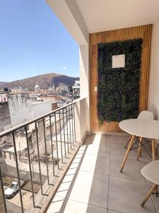 ein Balkon mit Tischen und einer grünen Wand in der Unterkunft Dpto ubicacion perfecta cuatro habitaciones tres baños en calle caseros, renovado y remodelado - Bonavista Rentals in Salta