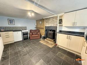 a kitchen with a couch and a chair in a room at Hundy Cottage in Alston