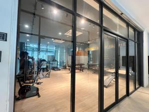 a gym with large glass windows and exercise equipment at Apartment Kota Samarahan in Kota Samarahan