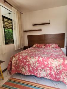 ein Schlafzimmer mit einem Bett mit einer roten geblümten Tagesdecke in der Unterkunft Solange apartment-Casa Parque de Olivenca in Olivença + 48 Fotos