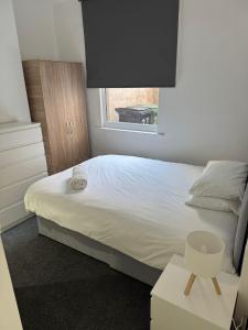 Un dormitorio con una cama blanca y una ventana. en Alderson House, en Hartlepool