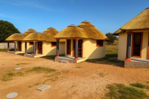 a row of cottages with thatched roofs at Ocean Crest Lodge in Zinkwazi Beach +6 photos