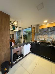 a kitchen with black and white cabinets and a counter at Casa completa para cop 30 in Belém +34 photos