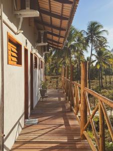 a wooden walkway outside of a house with palm trees at Windland Pousada Kite Center in Icaraí
