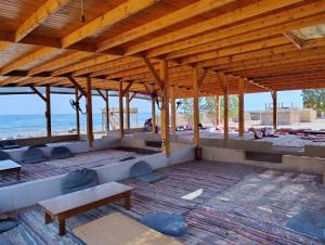 einen Pavillon mit einem Tisch und Bänken am Strand in der Unterkunft Luna Camp in Nuweiba