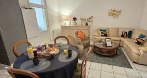 a living room with a table and chairs and a couch at T3 proche de bordeaux avec Terrasse in Villenave-dʼOrnon