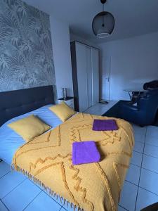 a bedroom with a bed with purple towels on it at T3 proche de bordeaux avec Terrasse in Villenave-dʼOrnon
