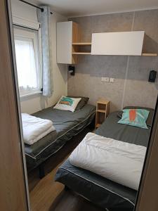 a small room with two beds and a window at Superbe mobil-home à Seignosse plage in Seignosse