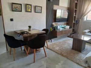 a living room with a wooden table and chairs at Cozy two bedroom apartment in Meknès