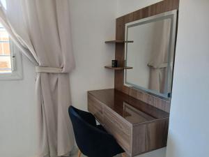 a dressing table with a mirror and a blue chair at Cozy two bedroom apartment in Meknès