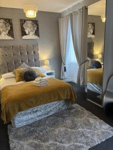 a bedroom with two beds and a large window at The Georgian Guesthouse in Alnwick