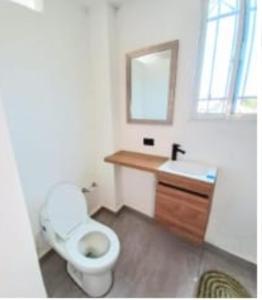 ein Badezimmer mit Toilette, Waschbecken und Spiegel in der Unterkunft Marine centro santa marta in Santa Marta