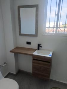 ein Badezimmer mit Waschbecken, Spiegel und Toilette in der Unterkunft Marine centro santa marta in Santa Marta
