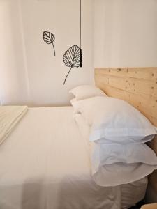 a bedroom with a white bed with white pillows at Dolcevita guest house in Torreano