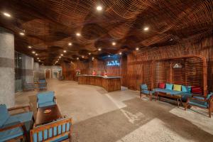 a large room with blue chairs and a bar at Avatar Danang Hotel in Da Nang