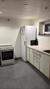 a kitchen with a refrigerator and a stove at Guesthouse Near Nature & Shops in Kolding