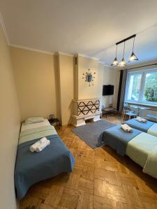 Un dormitorio con dos camas y un televisor. en Villa Gold Poznań, en Poznan 31 fotos más
