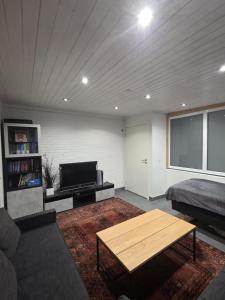 a living room with a bed and a couch and a table at Guesthouse Near Nature & Shops in Kolding