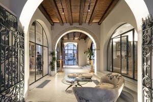 a lobby with arches and a chair and a table at Casa Clàt - Boutique Hotel in Cagliari