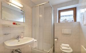 une salle de bain blanche avec un lavabo et une douche dans l'établissement Haus Adler by Alpine Host Helpers, à Westendorf 25 autres photos