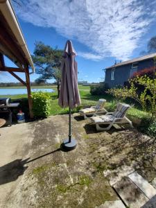 an umbrella and two chairs in a yard at Les Cabanes de Rouffignac in Rouffignac Saint-Cernin